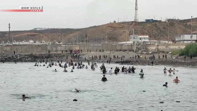 Thousands of migrants surge into Spanish enclave